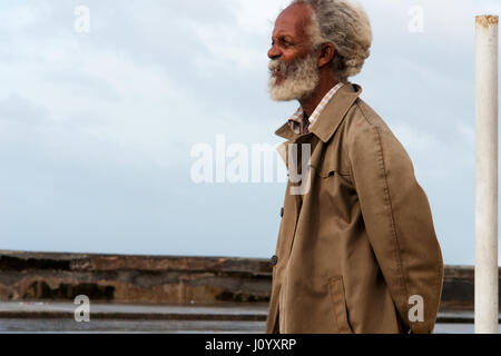 Old cuban man in a trench coat in Havana, Cuba Stock Photo