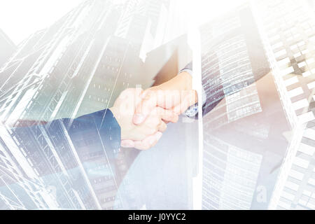 Double exposure of Close up businesswoman and businessman handshake with cityscape building, Business partnership concept.