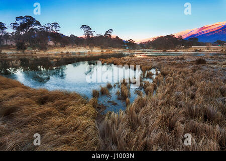 Thredbo valley of river and ponds aroung Crackenback resort in SNowy mountains of Australia. Cold winter morning set ice on pond's water and frost on  Stock Photo