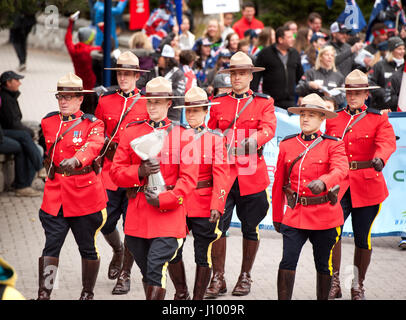 Royal Canadian Mounted Police, or RCMP officers in traditional dress red serge uniforms parade during the Canada Cup.  Whistler BC, Canada. Stock Photo