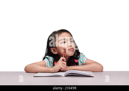 Cute asian girl studying with book and pencil isolated over white background Stock Photo