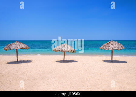 Straw umbrellas on a beautiful tropical beach Stock Photo