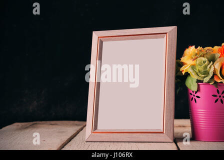 Picture frames and vases of flowers on the old wooden floor. Stock Photo