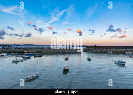 Mousehole, Cornwall, Uk. 17th April 2017. UK Weather. After a cloudy Easter Monday, the clouds lifted late in the day, for a colourful sunset over Mousehole harbour. Credit: Simon Maycock/Alamy Live News Stock Photo