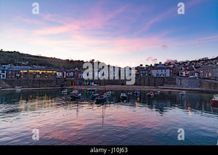 Mousehole, Cornwall, Uk. 17th April 2017. UK Weather. After a cloudy Easter Monday, the clouds lifted late in the day, for a colourful sunset over Mousehole harbour. Credit: Simon Maycock/Alamy Live News Stock Photo
