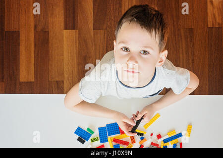 Little kid playing with colorful plastic construction bricks Stock Photo