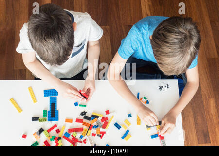 Kids playing with colorful plastic construction bricks Stock Photo