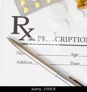 Pills and pen over medical prescription form - close up studio shot Stock Photo