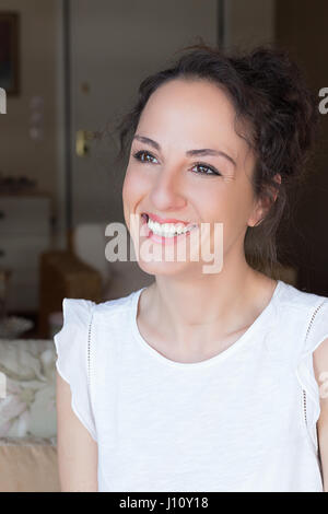 Portra of a greek young woman smiling, happy, looking away, indoors. Stock Photo