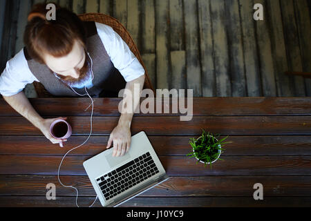 Young creative web-designer looking for data about modern trends Stock Photo