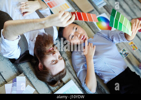 Professional designers looking at color swatches in hands Stock Photo