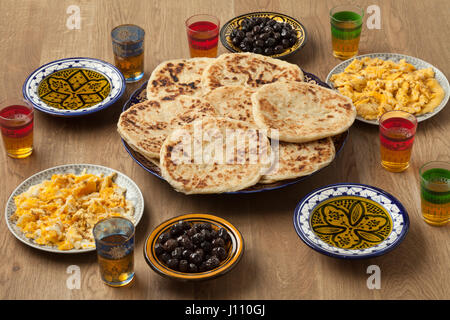 Traditional Moroccan  breakfast with pancakes,eggs,olives,olive oil and mint tea Stock Photo