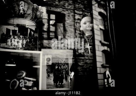 A shop displays a doll dressed as a penitent in the village of Bossost during the Holy week. The town of Bossost, located in the north of the Pyrenees Stock Photo