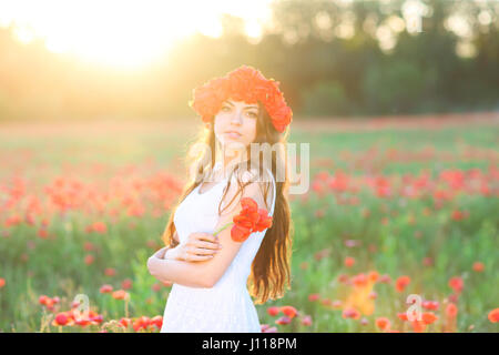 Young happy smiling woman in poppy field Stock Photo