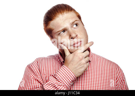 thoughtful thinking bearded readhead businessman with red shirt and freckles side looking. studio shot isolated on white. Stock Photo