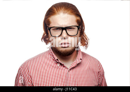 Thoughtful thinking bearded readhead businessman with red shirt and freckles and glasses looking at camera. studio shot isolated on white. Stock Photo