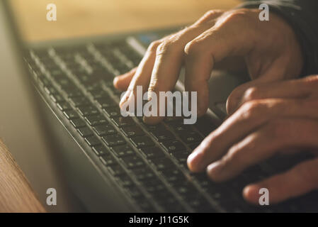 Computer programmer and hacker hands typing laptop keyboard, close up low key with selective focus Stock Photo