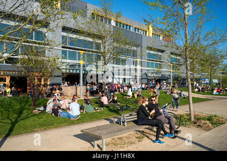 People enjoying sunny weather in pubs and restaurants in Here East, London England United Kingdom UK Stock Photo