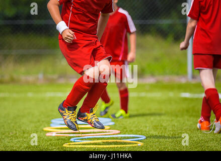 Young Soccer Player Practicing on the Pitch. Soccer Football Equpment. Dynamic Jumping Football Training Stock Photo