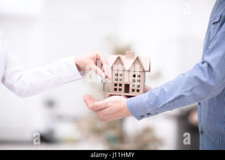 Female hand giving keys from new apartment to male hand on background Stock Photo