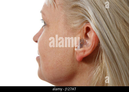modern digital hearing aid in woman's ear Stock Photo