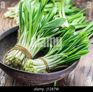 Young fresh wild garlic on the wooden table. Stock Photo