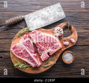 Steak T-bone with spices on the wooden cutting board. Stock Photo
