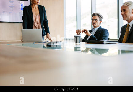 Businesspeople sitting at board room and discussing new strategies. Businessman and businesswoman meeting in conference room Stock Photo