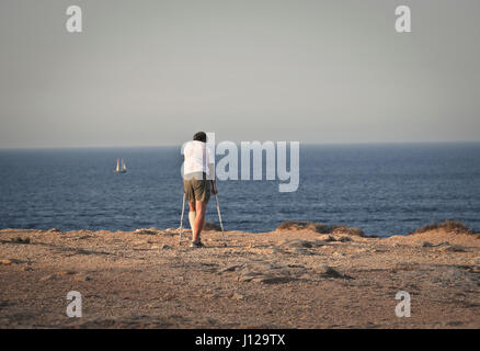 Handicapped man walking on beach Stock Photo