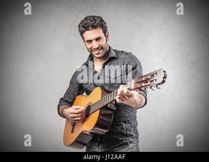 Handsome man playing on guitar Stock Photo