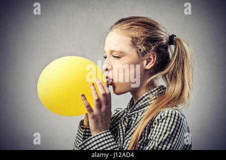 Blonde woman blowing balloon Stock Photo