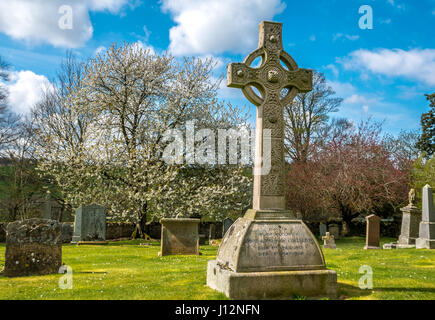 Celtic cross on grave and headstones in old churchyard with blue sky on a Spring day, Crichton Collegiate Church, Midlothian, Scotland, UK Stock Photo