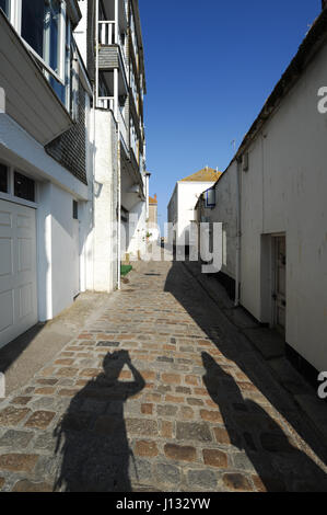 Shadows of people on a cobbled road in the town of St Ives, Cornwall, England. Stock Photo