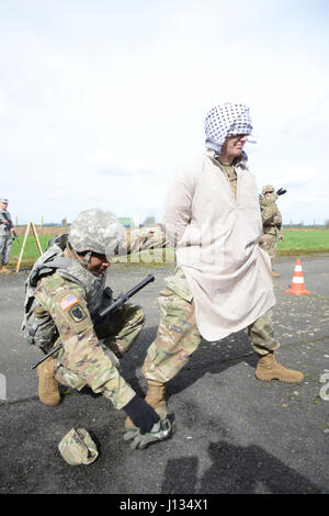 U.S. Army Sgt. Joel Delarosa assigned to 39th Signal Battalion, searches and empties the suspect' s pockets during the Entry Control Point Searching Vehicle Commander exercise, in Chièvres Air Base, Belgium, March 21, 2017. (U.S. Army photo by Visual Information Specialist Pascal Demeuldre) Stock Photo