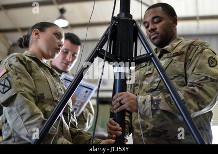 Sgt. Shereena Martinek (left) and Sgt. Marcel Nicholas assemble the mast for the BlueSky Mast AL1 wireless antenna at Schofield Barracks, Hawaii, on April 3, 2017. Both Soldiers are assigned to the signal section (S6) for Headquarters and Headquarters Battery, 25th Division Artillery, 25th Infantry Division. The new AL1 wireless antenna will allow Soldiers to communicate on a secure wireless network on the battlefield. (U.S. Army photo by Staff Sgt. Armando R. Limon, 3rd Brigade Combat Team, 25th Infantry Division) Stock Photo