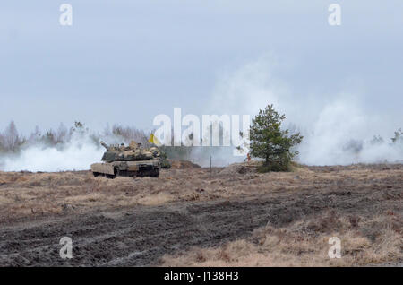 Ādaži, Latvia - Soldiers from Company A, 1st Battalion, 68th Armored Regiment, 3rd Armored Brigade Combat Team, 4th Infantry Division, out of Fort Carson, Colo., conduct a tank live-fire and react-to-fire exercise on Ādaži military base as a part of Operation Atlantic Resolve, April 9. This live fire was part of a platoon-level training exercise to familiarize Soldiers with local terrain as well as how to react under pressure to situations such as loss of communication with higher headquarters, loss of global positioning system and chemical attack. The 3rd ABCT is trained to operate in any env Stock Photo