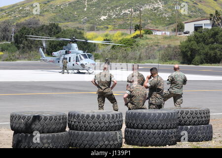 Marines with the School of Infantry (SOI) West observe a UH-1Y Huey with Marine Light Attack Helicopter Training Squadron (HMLAT) 303 during an aerial demonstration at Marine Corps Base Camp Pendleton, Calif., April 11. Marines with HMLAT-303 conducted basic flight maneuvers during the demonstration to build cohesion between air and ground Marines. (U.S. Marine Corps photo by Lance Cpl. Jake M.T. McClung/Released) Stock Photo