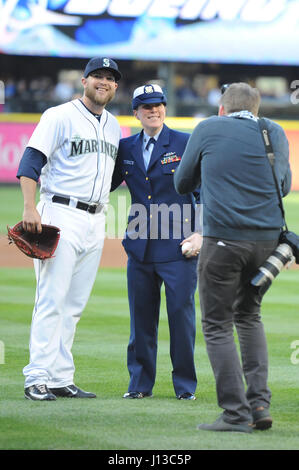 Petty Officer 1st Class Tara Dodd (center), a culinary specialist aboard the Coast Guard Cutter Swordfish in Port Angeles, poses for a photo with the Mariners player who acted as her catcher as part of a commemorative first pitch during the opening ceremony for the Mariners' 15th Annual Salute to Armed Forces Night at Safeco Field in Seattle, April 15th, 2017.    Service members were selected to throw the first pitch for their respective branch due to their distinguished work, with Dodd recently awarded the title of Coast Guard 13th District Enlisted Person of the Year for her work throughout  Stock Photo