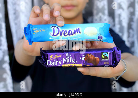 Hand holding Australia Cadbury white chocolate and Dairy Milk chocolate bar Stock Photo