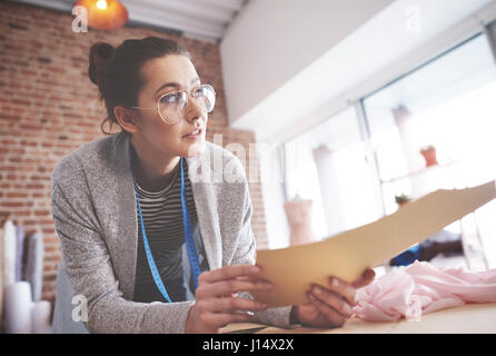 Tailor with patterns looking away Stock Photo