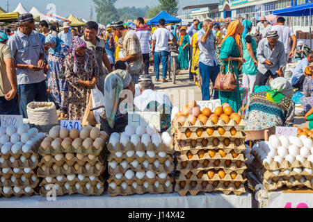 MARGILAN, UZBEKISTAN - AUGUST 21: Eggs for sale and a crowd of people visiting Kumtepa bazaar. Market is one of the biggest in the area running once a Stock Photo