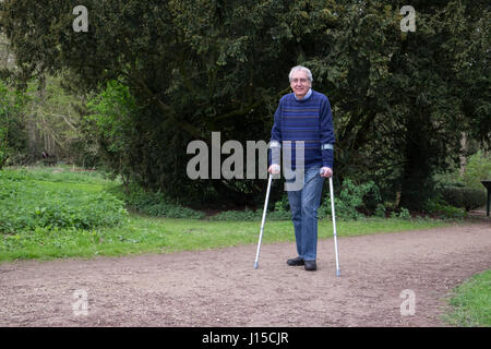 Senior man walking with crutches Stock Photo