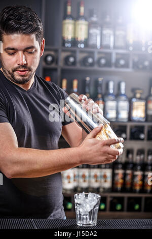 Cool professional bartender making a cocktail, shaking a cocktail shaker.  Authentic barman making alcohol beverages in modern bar. High quality photo  Stock Photo - Alamy