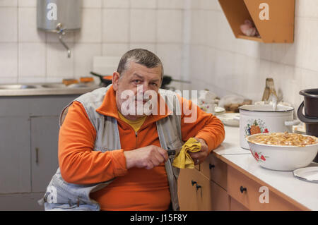 Portrait of bearded senior man working in kitchen Stock Photo