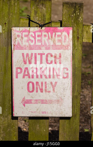 Quirky faded sign stating Witch parking only reserved on a wooden gate Stock Photo