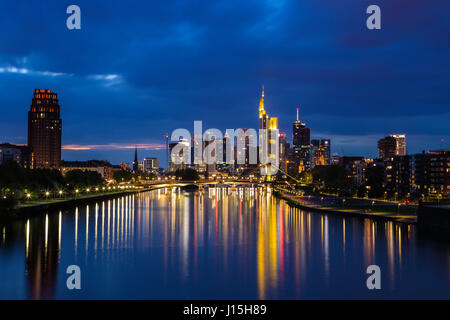 Night photograph of the skyline of Frankfurt am Main with view over the Main river and reflections of the skyscrapers in the water Stock Photo