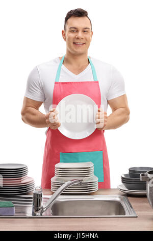 Young man in an apron showing a clean plate isolated on white background Stock Photo