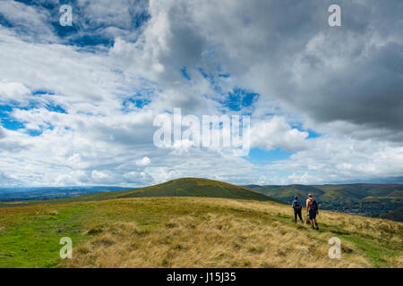 Walkers on Willstone Hill with the main top of Hope Bowdler Hill in the distance, in the Hope Bowdler hills, near Church Stretton, Shropshire, England Stock Photo