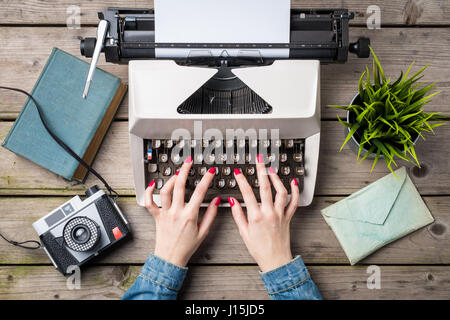 Woman writing on an old typewriter Stock Photo
