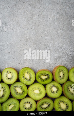 flat lay of organic kiwi fruit on green and pink Stock Photo by  LightFieldStudios